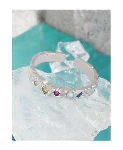 Macro d'une bague en argent à texture irrégulière avec pierres précieuses sur glace