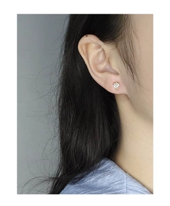 Vue détaillée d'une boucle d'oreille cœur dorée avec zircon blanc portée