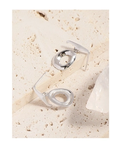 Detailed view of minimalist S925 sterling silver irregular oval earrings on a stone base