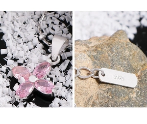 Macro shot of S925 sterling silver stamp and pink zircon flower pendant on a fine chain