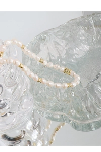 Détail macro d'un collier en argent S925 avec perles baroques et perles dorées