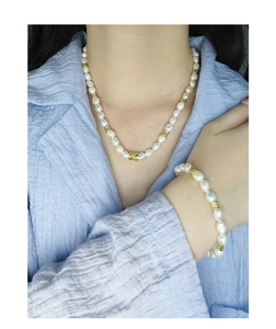 Gros plan d'un ensemble collier et bracelet en perles d'argent S925 sur un mannequin