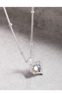 Macro d'un collier cœur en argent S925 avec pierre de lune bleue et chaîne à perles