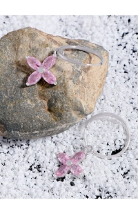 Gros plan de boucles d'oreilles fleur en argent S925 et zircon rose sur pierre naturelle