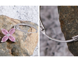 Détail d'une boucle d'oreille en argent S925 avec fleur en zircon rose et gravure