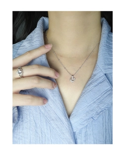 Détail du collier coeur en pierre de lune et bague assortie sur mannequin en bleu
