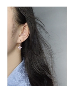 Gros plan de créoles élégantes en argent S925 avec pendentifs fleur de cerisier rose