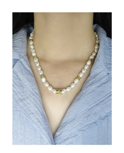 Détail du collier de perles en argent S925 avec perles dorées porté par un mannequin