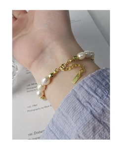 Détail du poinçon S925 sur le bracelet en perles dorées avec chaîne élégante