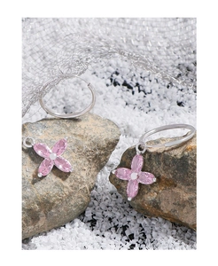 Vue macro de boucles d'oreilles cerisier en argent avec zircons roses sur pierre brute