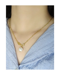 Close-up of S925 silver chain necklace with baroque pearl and golden heart charm