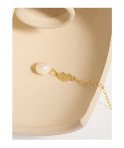 Detail of 18K gold chain necklace with freshwater pearl and golden lip pendant