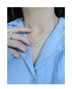 Close-up of a model wearing a heart opal necklace and ring with twisted texture