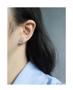 Close-up of minimalist S925 silver moonstone stud earring worn by a model