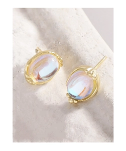Macro detail of S925 silver moonstone stud earrings with vintage gold floral settings