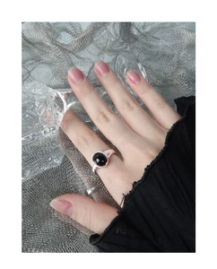 Close-up of a minimalist silver open ring with a smooth oval black agate stone inlay