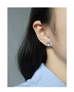 Close-up of S925 sterling silver moonstone stud earrings with crown setting on model