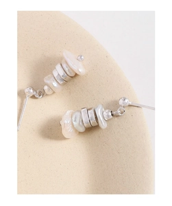 Close-up of S925 silver stud earrings with irregular baroque pearls on a ceramic tray