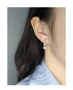 Macro detail of minimalist S925 silver stud earring with irregular pearl on model ear