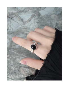 Close-up of minimalist S925 silver ring with oval black onyx stone on model finger