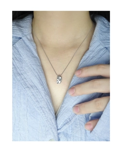 Gros plan d'un collier irrégulier en argent S925 porté sur le cou de la mannequin