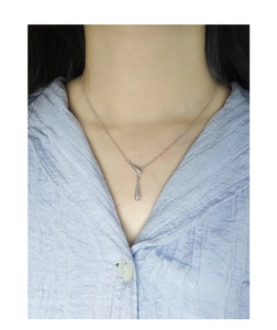 Détail d'un collier pendentif goutte d'eau en argent sterling S925 poli sur un modèle