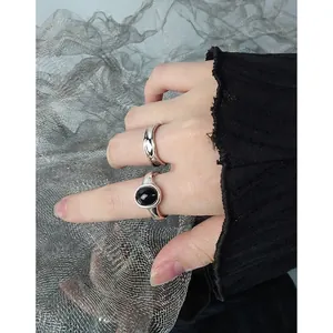 Minimalist S925 silver ring set with wavy band and oval black onyx stone on model hand
