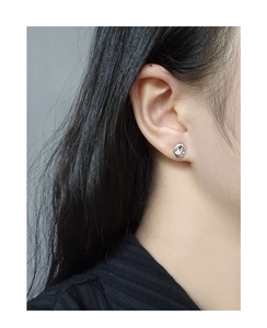 Nahaufnahme eines minimalistischen S925-Silberohrrings mit unregelmäßiger Form