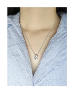 Vue détaillée du pendentif fève irrégulier en argent poli avec une chaîne serpent fine