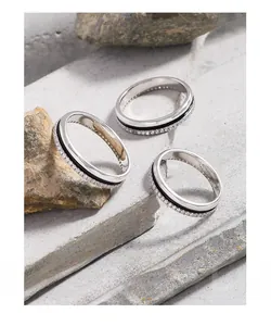 Macro shot of silver stacking rings with black enamel inlay and pave-set zircons on stone
