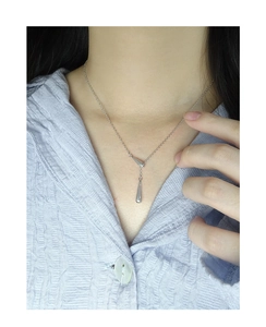 Vue détaillée d'un collier pendentif goutte d'eau en argent S925 sur le cou d'un modèle