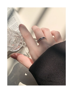 Macro detail of a layered black enamel and silver ring with sparkling zircon stones