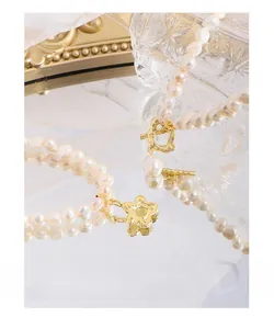 Close-up of S925 silver flower and heart OT buckles on baroque pearl necklaces