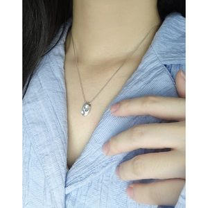 Collier minimaliste en argent sterling S925 avec pendentif haricot porté par un mannequin