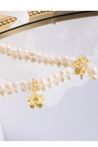 Detailed close-up of Baroque pearl necklace with gold floral pendant and OT toggle clasp