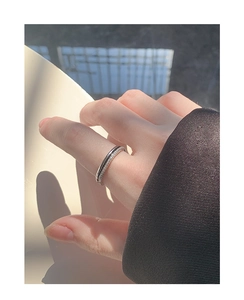 Detail of a minimalist double-layer S925 silver ring with pavé zircon stones on finger