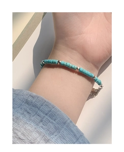 Detail of S925 sterling silver beaded bracelet with turquoise stones on female wrist