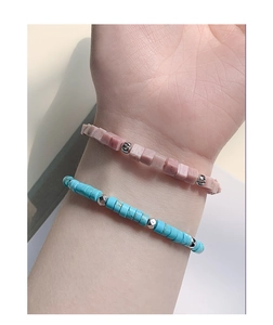 Close-up of minimalist S925 silver beaded bracelets with pink and turquoise stones