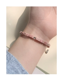 Detail of pink rhodochrosite and silver bead bracelet on female wrist with adjust chain