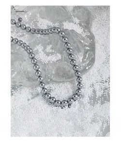 Macro shot of grey pearls with metallic luster on ice prop for S925 silver necklace