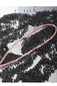 Detail view of beaded necklace with pink stone cylinders and silver bamboo spacers