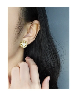 Détail de boucles d'oreilles vintage françaises avec base dorée et perles blanches