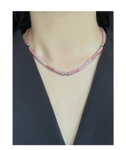 Detail of S925 silver necklace with pink rhodochrosite stones on woman neckline