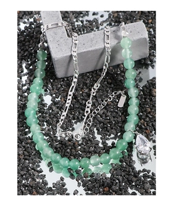 Detail of beaded necklace with teardrop gemstone and silver metal chain link