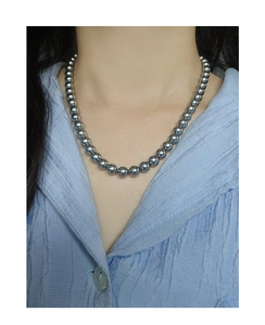 Close-up of minimalist grey pearl necklace on neck showing luster and texture