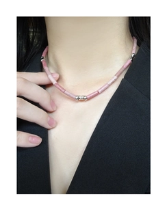 Detail of pink stone tube necklace with silver beads worn on a black blazer outfit