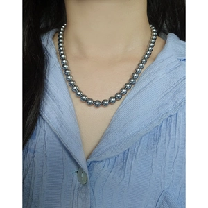 Elegant 925 sterling silver necklace with high-luster dark grey pearls on a female model
