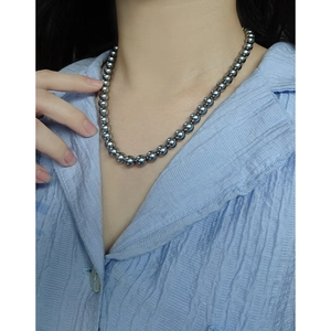 Elegant grey pearl necklace in S925 sterling silver worn by model with blue shirt