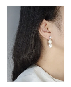 Close-up of triple Baroque pearl drop earrings on model showing natural texture and gloss