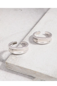 Macro detail of silver minimalist open rings with irregular concave textured finish